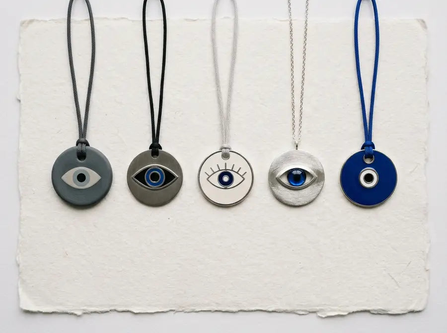 Grey, black, white, silver-toned and blue evil eye charms arranged for comparison; verify against the final visible image.