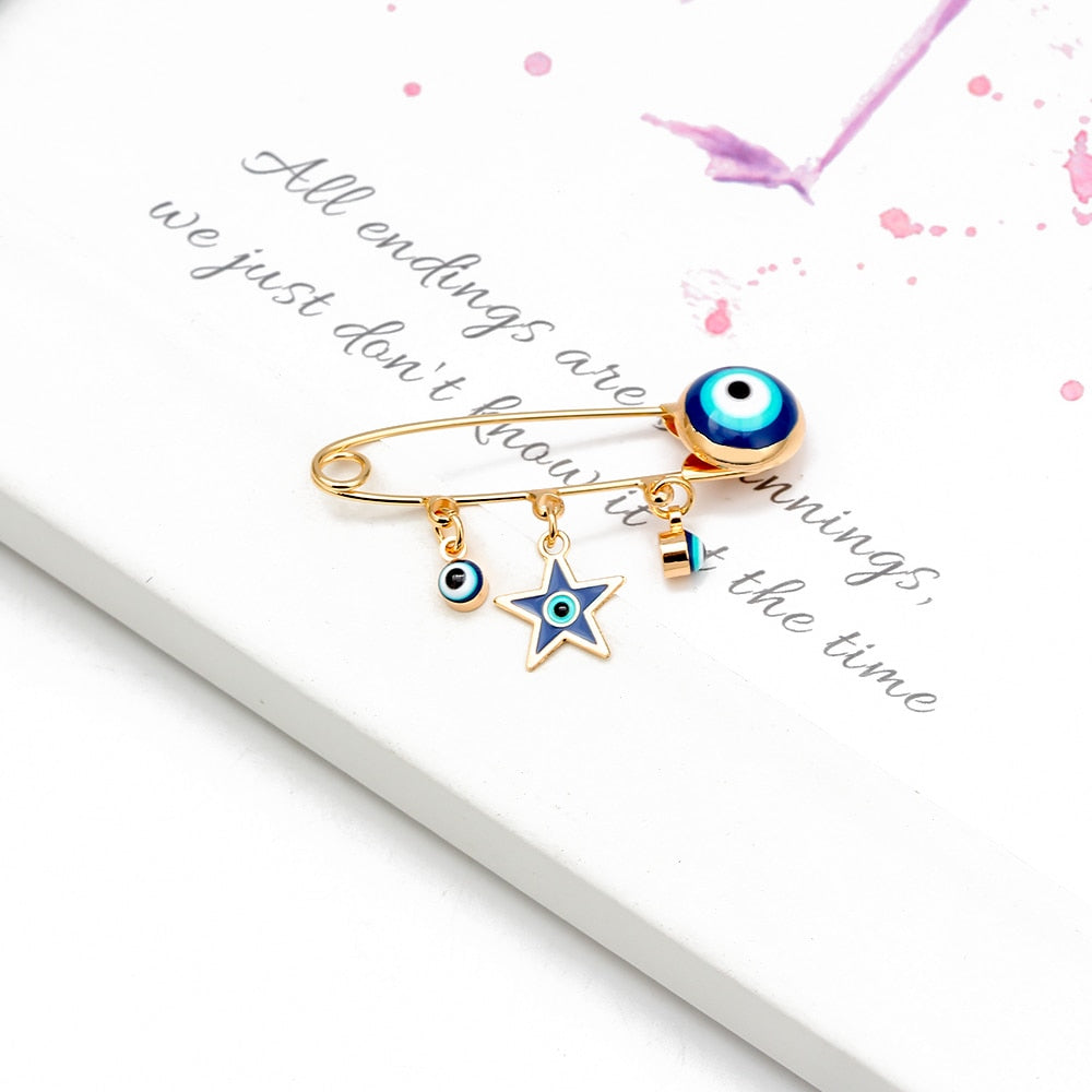 Ward off Bad Luck with our Turkish Evil Eye Brooch Pin with Flower Crown, Hamsa Hand, and Star Charms