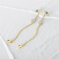 Gold tone evil eye earrings with Hamsa details, extended chains and detached backs
